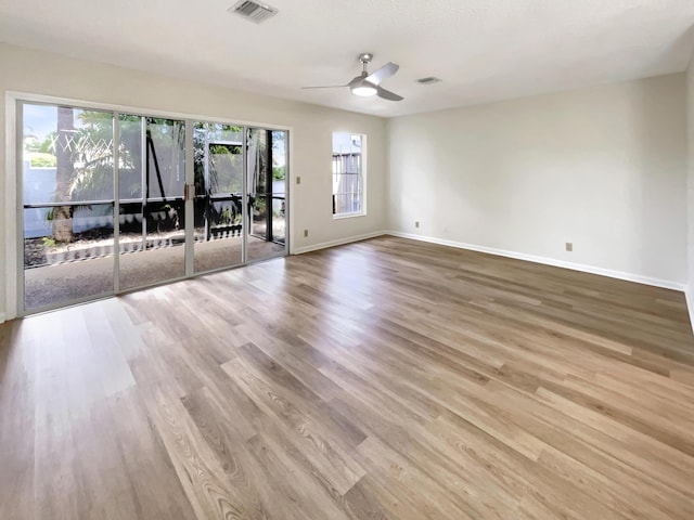 empty room with ceiling fan and light hardwood / wood-style flooring