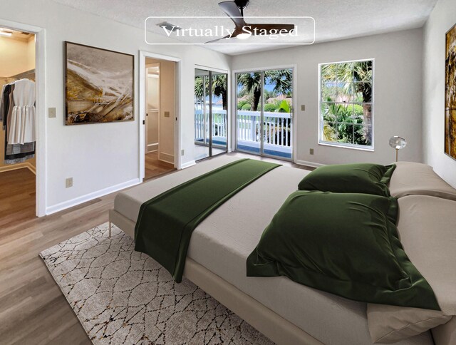 bedroom with a textured ceiling, ceiling fan, hardwood / wood-style floors, and access to exterior