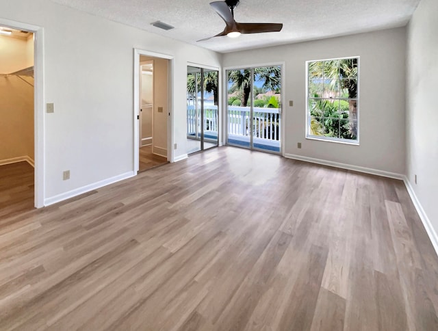 spare room with a textured ceiling, ceiling fan, and hardwood / wood-style floors