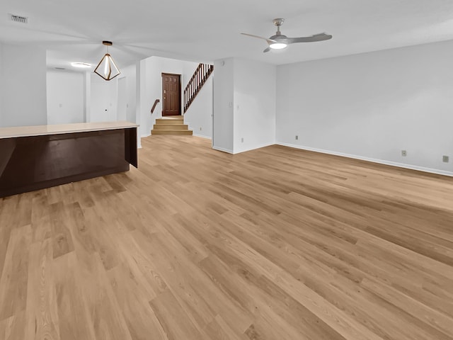 unfurnished living room featuring ceiling fan and light hardwood / wood-style flooring