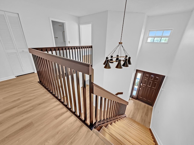 staircase featuring a chandelier and wood-type flooring