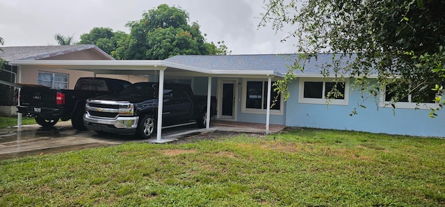 single story home with a front yard and a carport