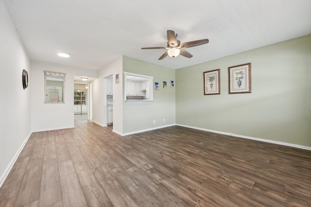 empty room with hardwood / wood-style flooring, a textured ceiling, and ceiling fan