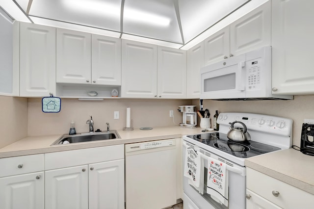 kitchen featuring white cabinetry, sink, and white appliances