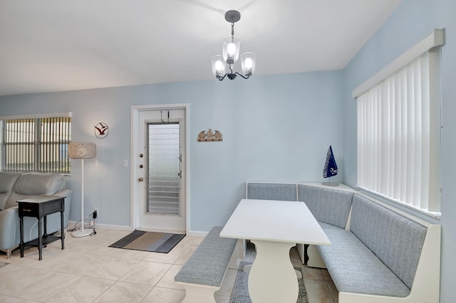 dining room featuring light tile patterned flooring and a notable chandelier