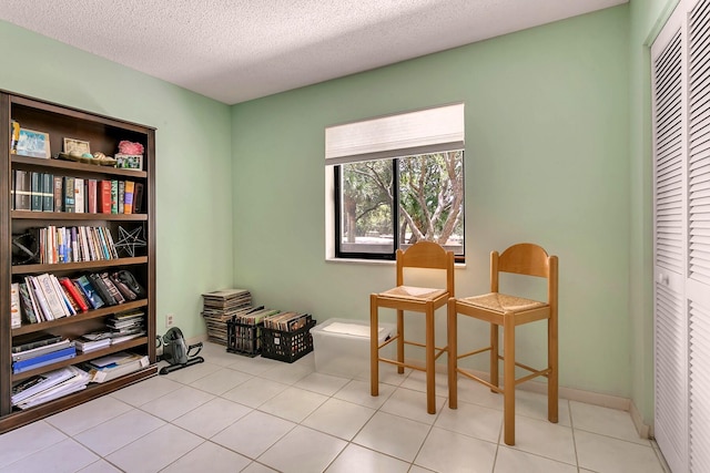 sitting room featuring light tile patterned floors and a textured ceiling