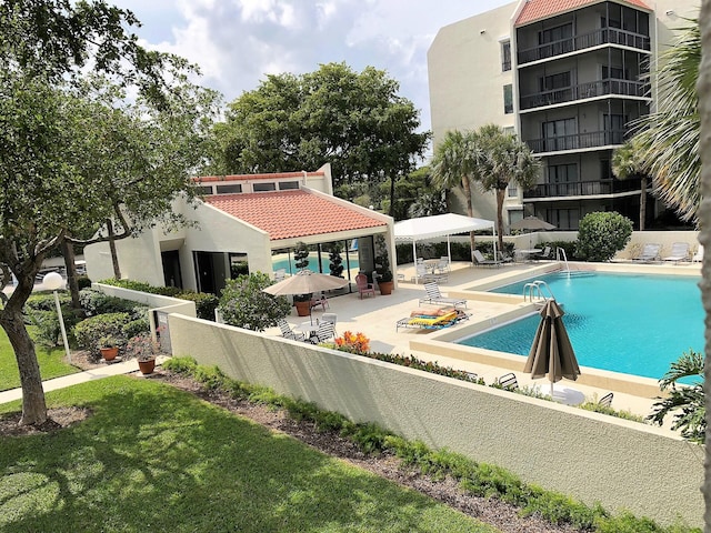 view of swimming pool featuring a lawn and a patio