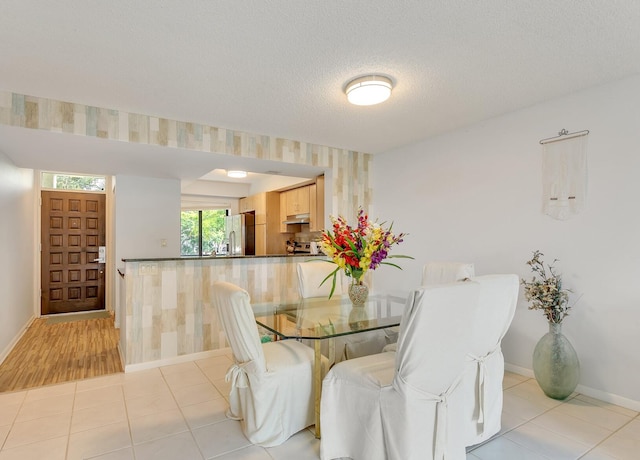 tiled dining area featuring a textured ceiling