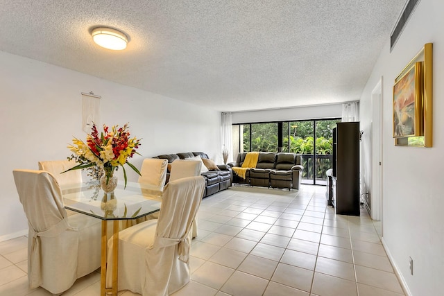 tiled dining space with a textured ceiling and a baseboard heating unit