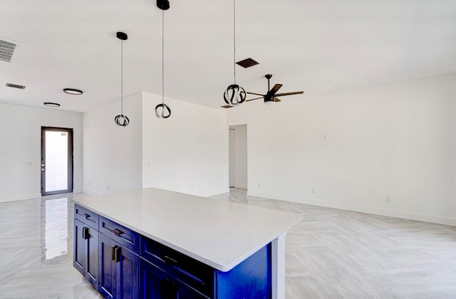 kitchen featuring blue cabinets, a center island, and pendant lighting