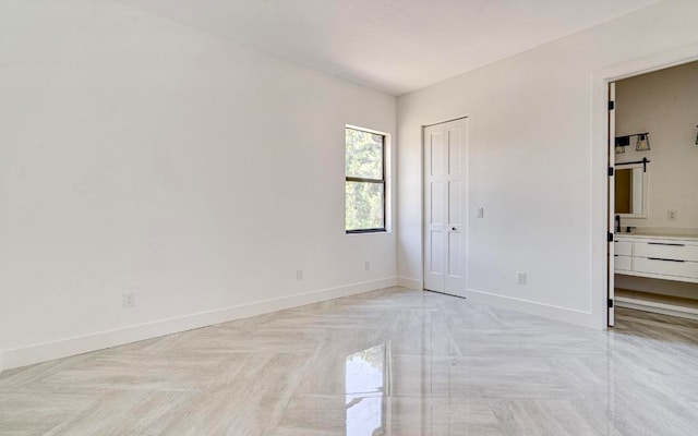 unfurnished bedroom with light parquet flooring and ensuite bath