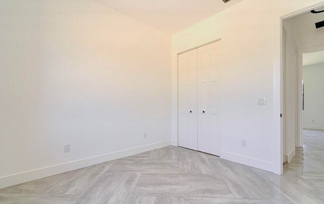 unfurnished bedroom with light parquet flooring and a closet