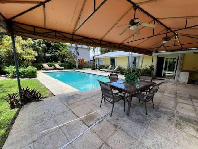 view of swimming pool with ceiling fan and a patio area