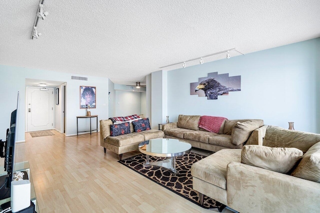 living room featuring a textured ceiling and rail lighting