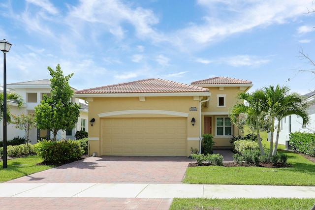 mediterranean / spanish home featuring a front yard and a garage