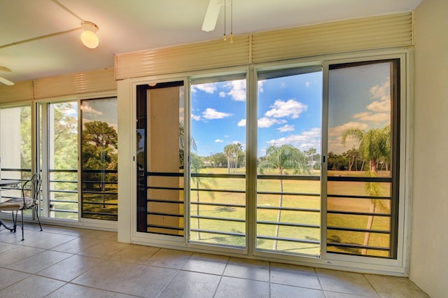 doorway featuring light tile patterned floors and ceiling fan