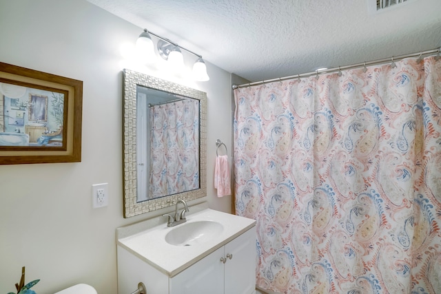 bathroom with a textured ceiling and vanity