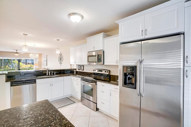 kitchen with light tile patterned flooring, sink, appliances with stainless steel finishes, ceiling fan, and white cabinets