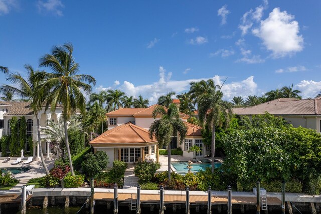 rear view of property featuring french doors, a patio area, a swimming pool with hot tub, and ceiling fan