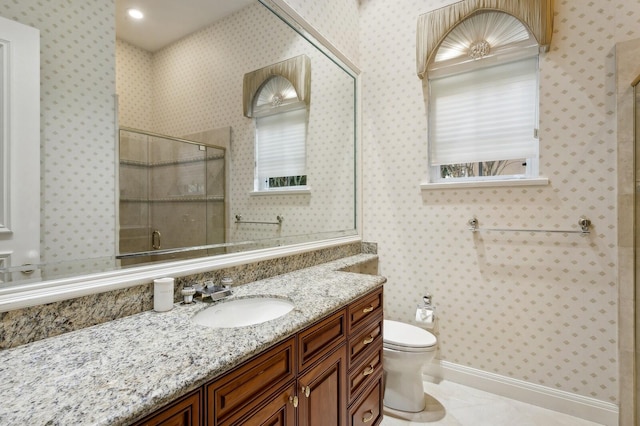 bathroom with vanity, a shower with shower door, toilet, tile patterned floors, and a wealth of natural light