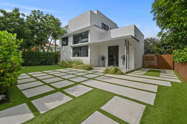 back of property with a lawn and a patio