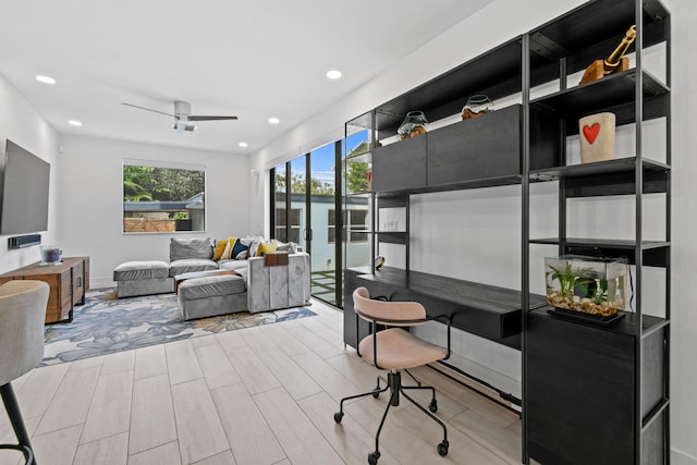 office featuring a water view, ceiling fan, and light hardwood / wood-style flooring