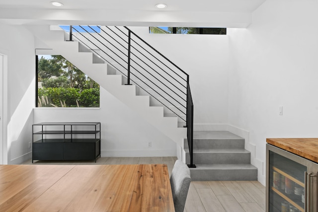 stairway featuring hardwood / wood-style floors and beverage cooler