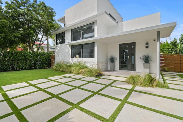 back of property with french doors and a yard