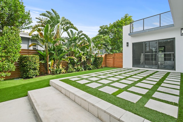 view of yard with a balcony and a patio area