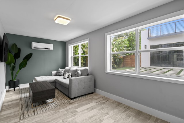 living room featuring a wall mounted AC and light hardwood / wood-style flooring