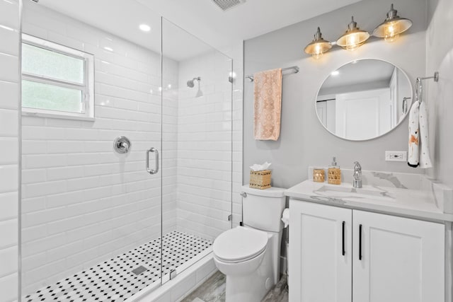 bathroom featuring hardwood / wood-style floors, a shower with shower door, vanity, and toilet