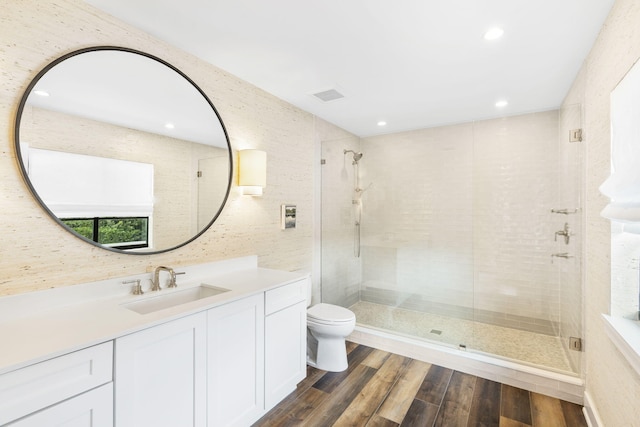 bathroom featuring vanity, hardwood / wood-style floors, a shower with door, and toilet