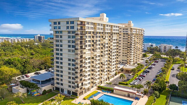 view of building exterior featuring a water view and a community pool