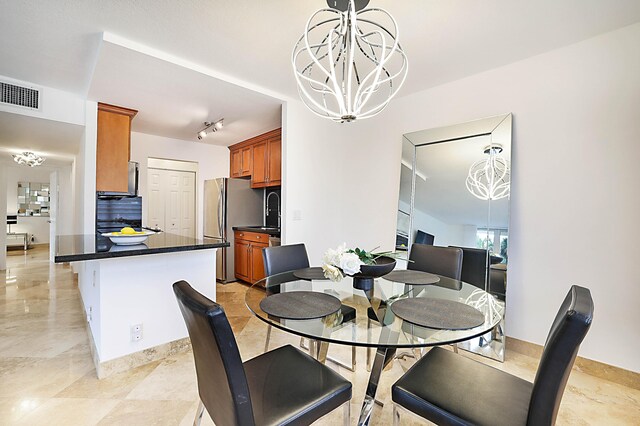 tiled dining area with an inviting chandelier and track lighting