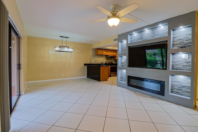 unfurnished living room with ceiling fan, sink, and light tile patterned flooring