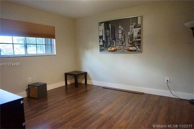 unfurnished room with dark hardwood / wood-style flooring