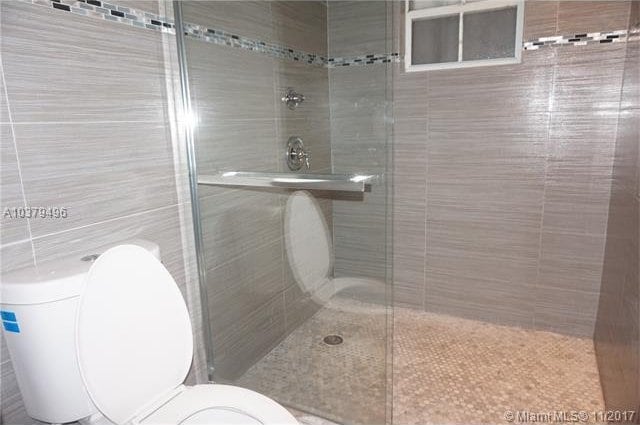 bathroom with an enclosed shower and toilet