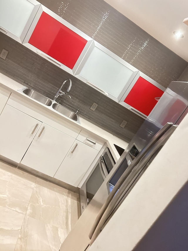 kitchen featuring white cabinetry, sink, and backsplash