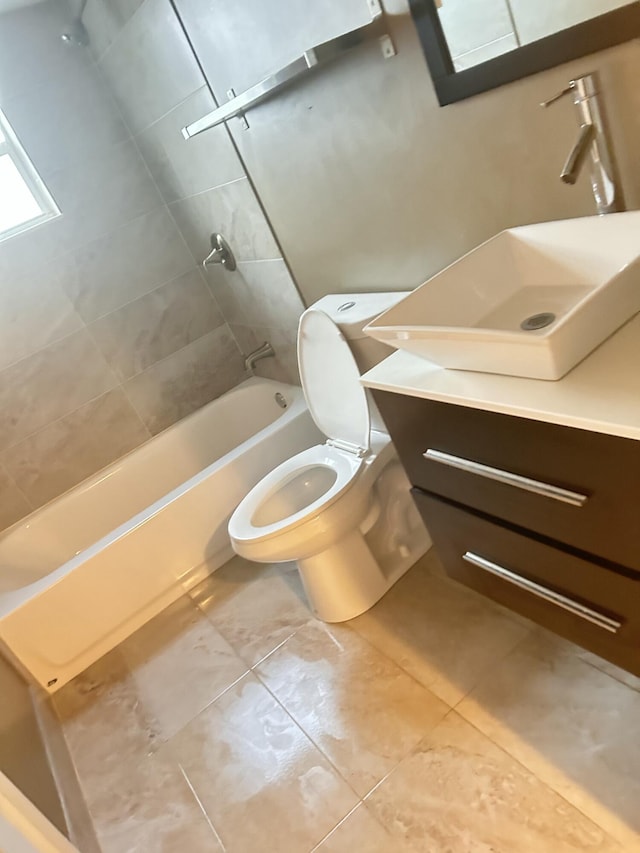 full bathroom with tile patterned floors, vanity, toilet, and tiled shower / bath combo