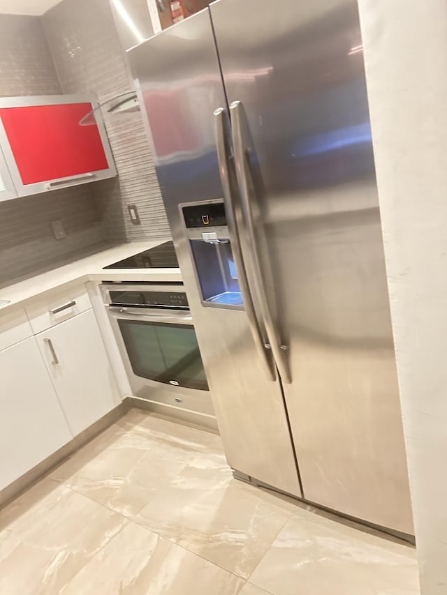 kitchen featuring white cabinetry, decorative backsplash, and appliances with stainless steel finishes