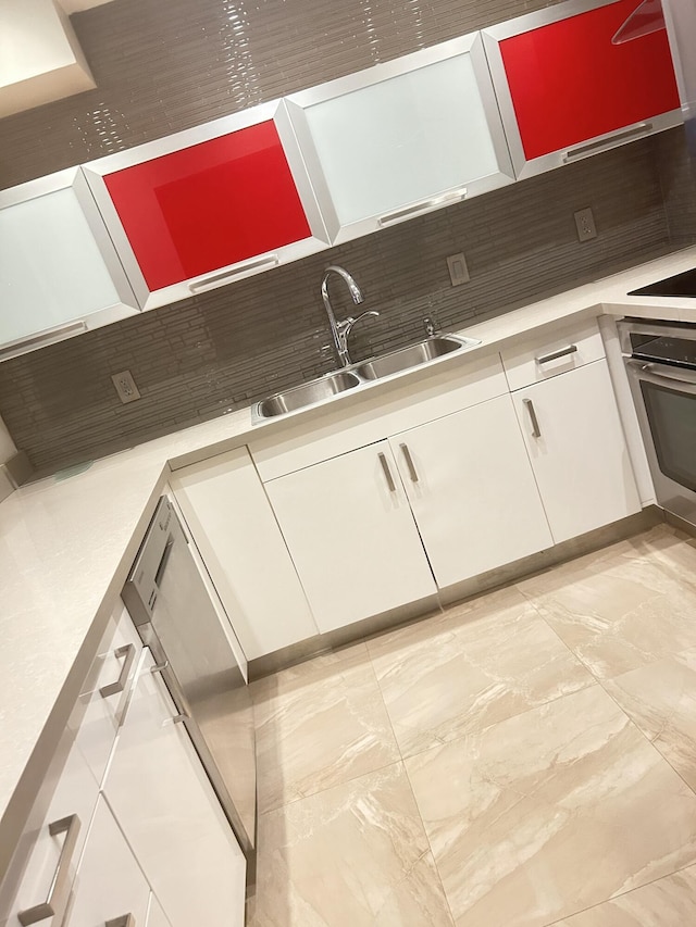 kitchen featuring white cabinetry, sink, decorative backsplash, and oven