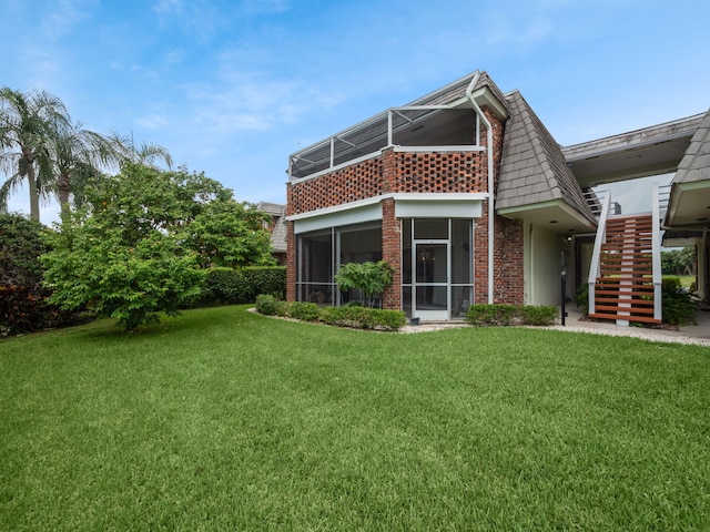 back of house featuring a yard and a sunroom