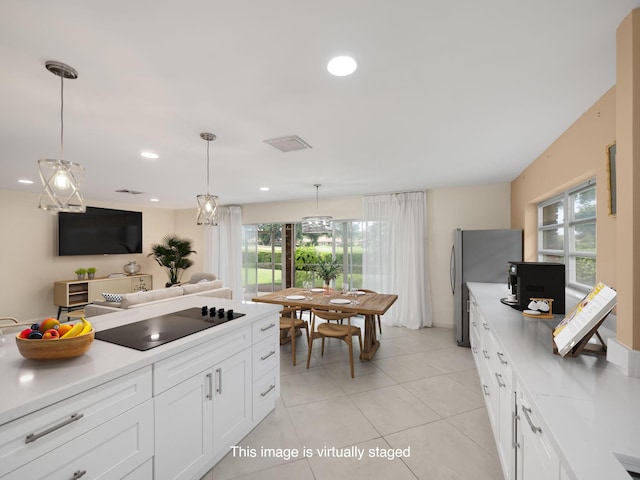 kitchen featuring white cabinets, a healthy amount of sunlight, and decorative light fixtures