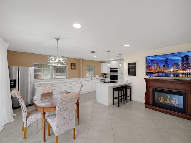 tiled dining area featuring sink and a notable chandelier