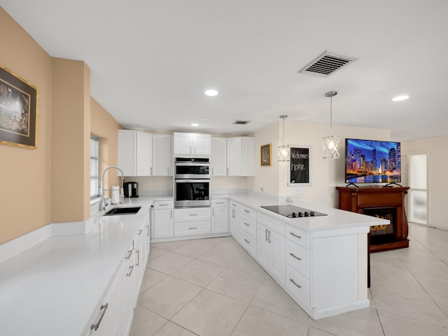 kitchen featuring kitchen peninsula, stainless steel double oven, sink, black electric stovetop, and white cabinets