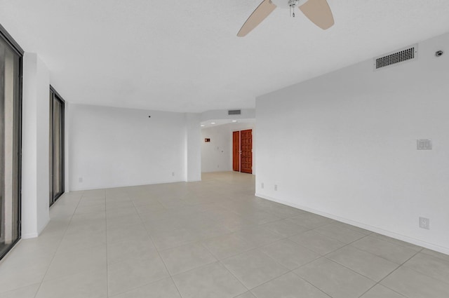 tiled spare room featuring ceiling fan