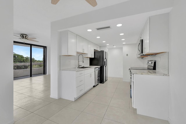 kitchen with white cabinetry, tasteful backsplash, stainless steel appliances, sink, and ceiling fan