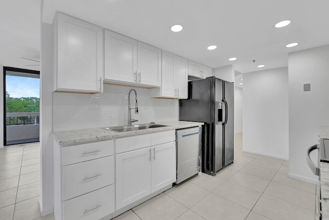 kitchen featuring white cabinets, dishwashing machine, light stone countertops, sink, and black fridge