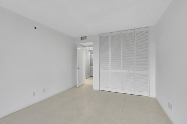 unfurnished bedroom with light tile patterned floors and a closet