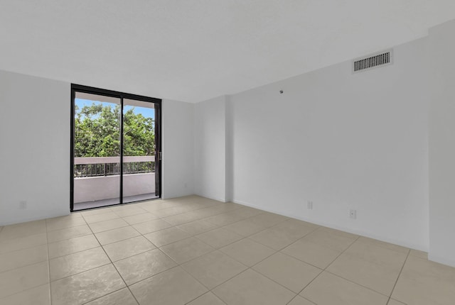 tiled spare room featuring floor to ceiling windows